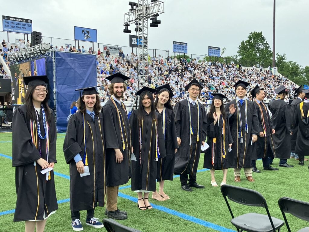 A group of students are wearing graduation gowns and caps.