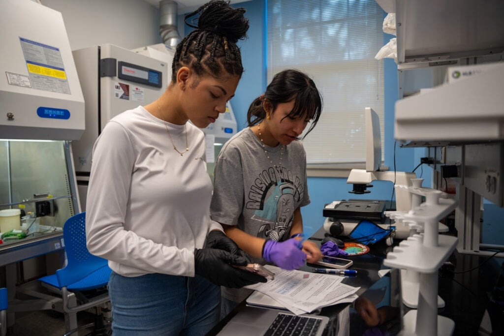 Two female students are working in a lab.