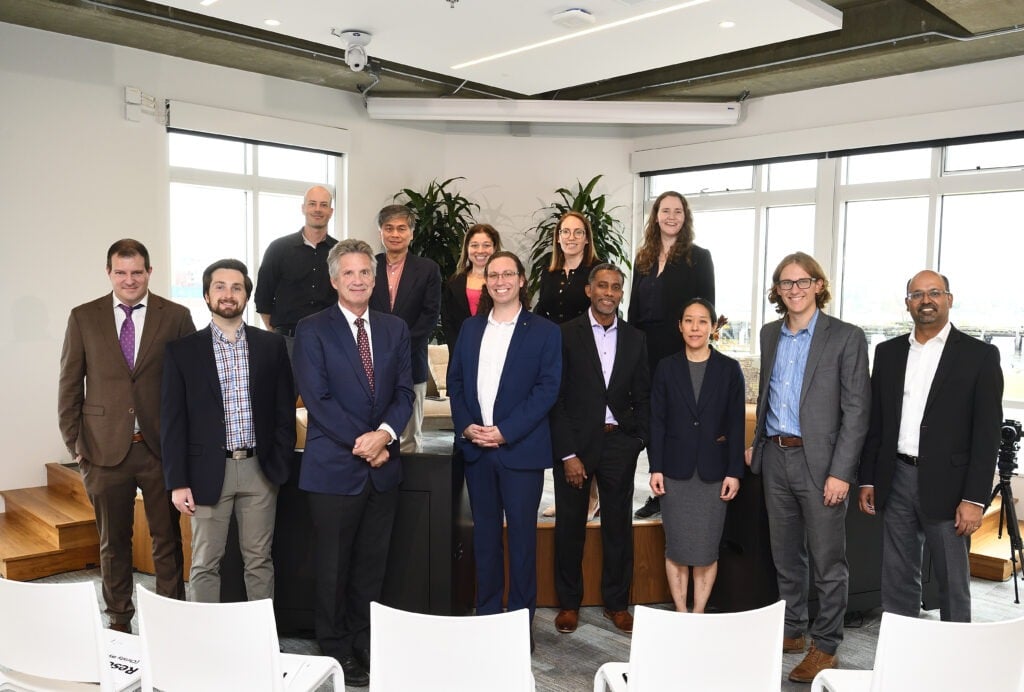 A group of business people gather for a photo.